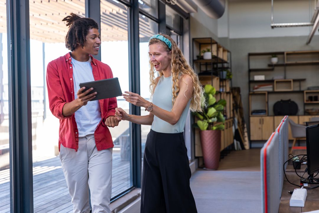 Collaborative Colleagues Engaging with Digital Tablet in Modern Office Space