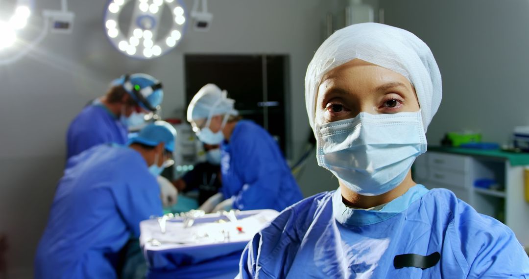 Confident Surgeon in Operating Room with Medical Team in Background - Free Images, Stock Photos and Pictures on Pikwizard.com