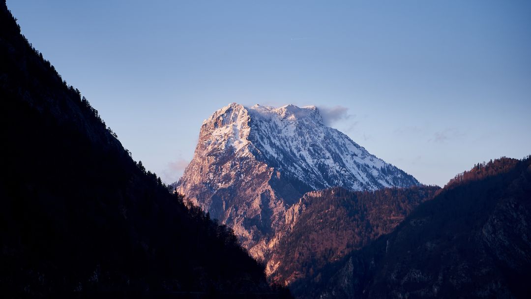 Snow-capped mountain peak at sunrise with valley view - Free Images, Stock Photos and Pictures on Pikwizard.com