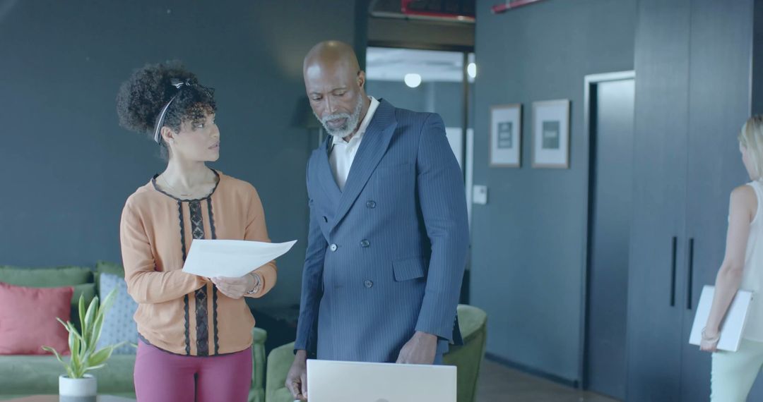 Business Colleagues Reviewing Documents in Modern Office