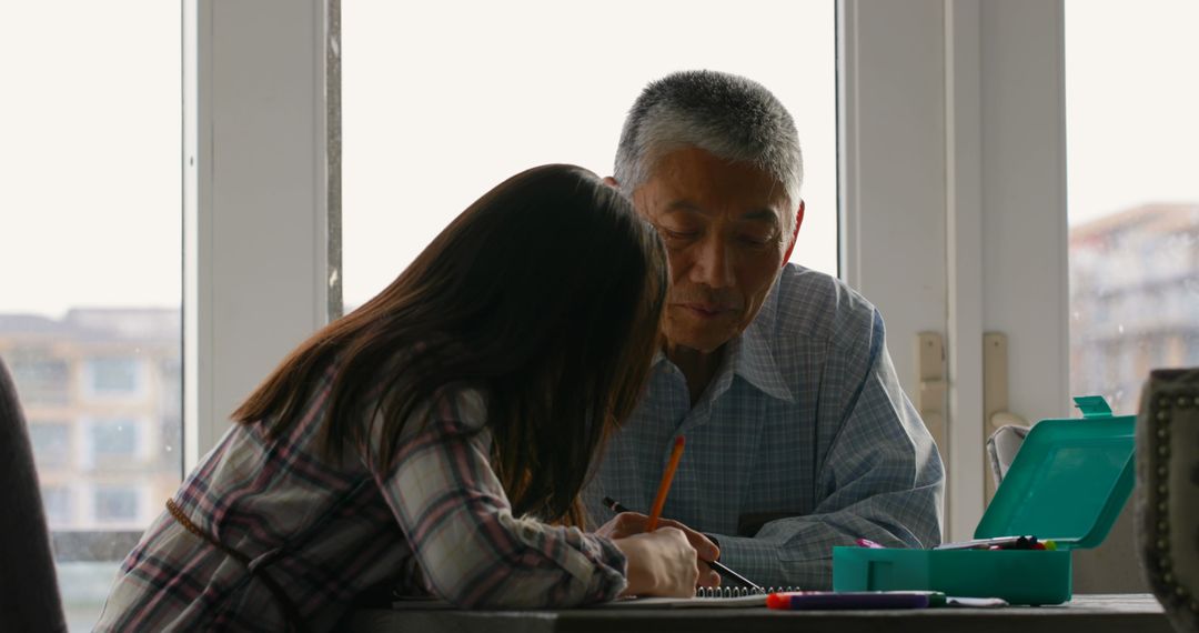 Grandfather Helping Girl with Homework at Home - Free Images, Stock Photos and Pictures on Pikwizard.com