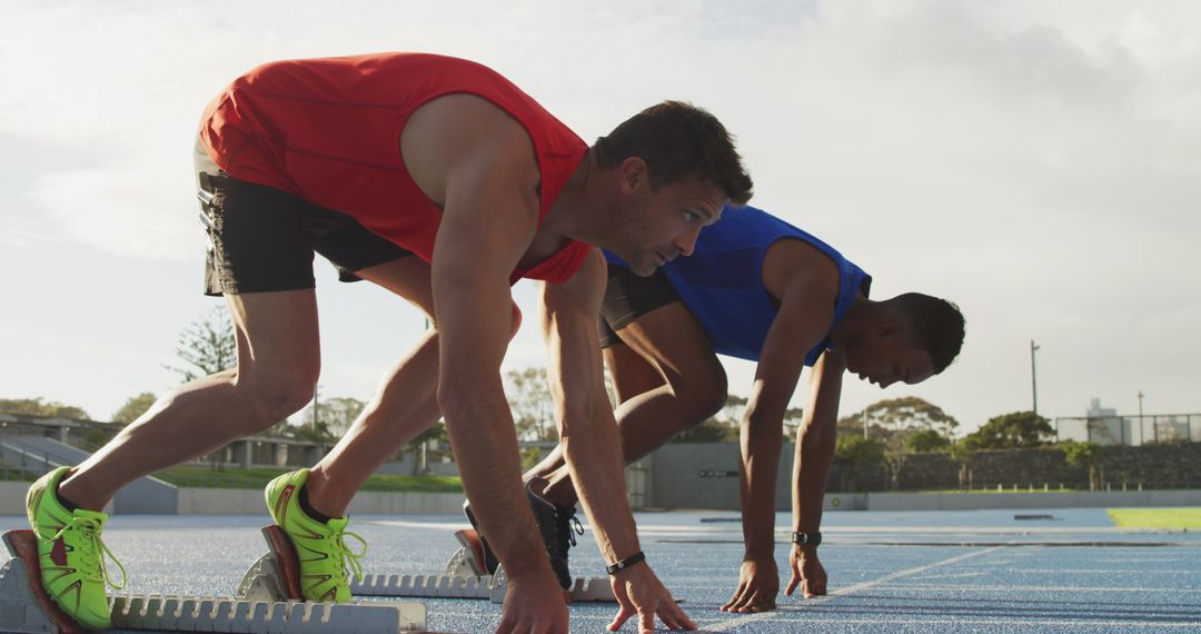 Two Track Athletes Preparing on Starting Blocks Outdoors