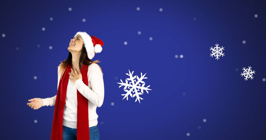 Smiling Woman in Santa Hat and Scarf Enjoying Snowflakes