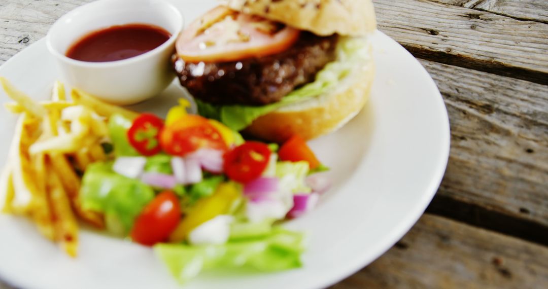 Delicious Burger with Fresh Salad and Fries on Wooden Table - Free Images, Stock Photos and Pictures on Pikwizard.com