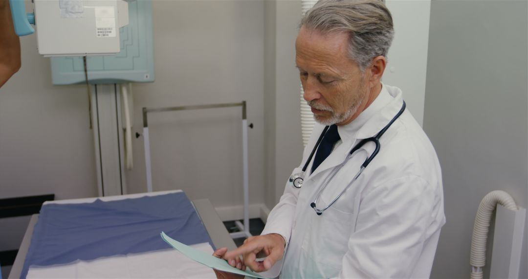 Senior Doctor Reviewing Patient Chart in Examination Room - Free Images, Stock Photos and Pictures on Pikwizard.com