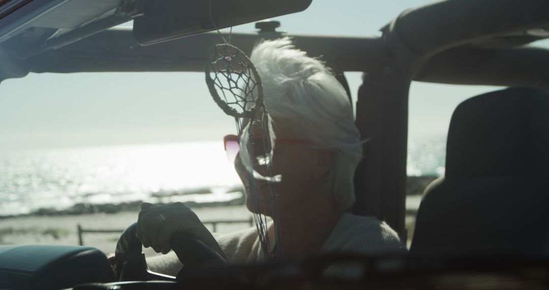 Joyful Senior Woman Driving by the Sea on a Sunny Day - Free Images, Stock Photos and Pictures on Pikwizard.com