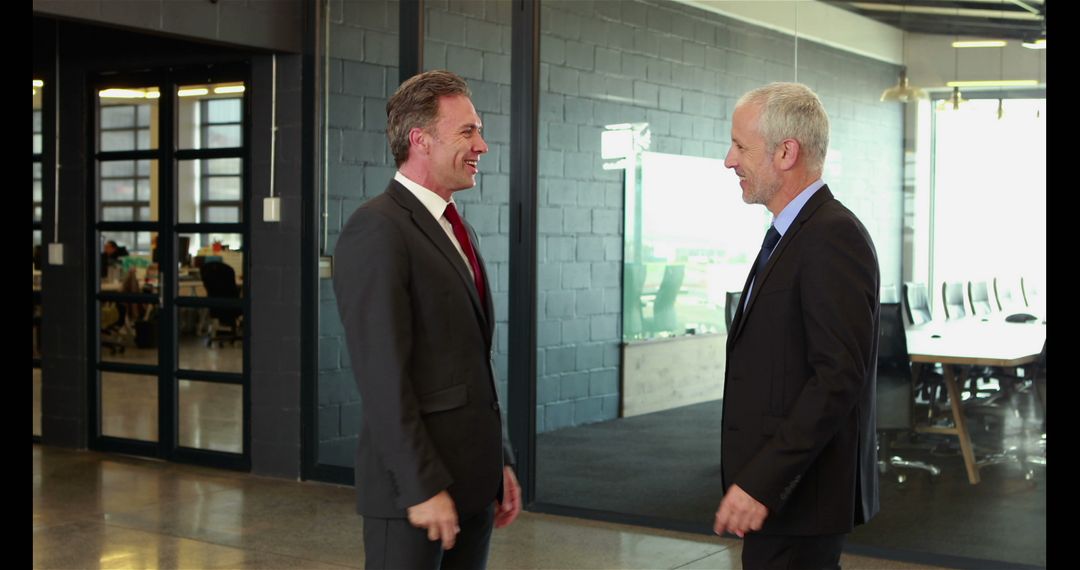 Two Businessmen in Formal Suits Having a Conversation in Modern Office - Free Images, Stock Photos and Pictures on Pikwizard.com