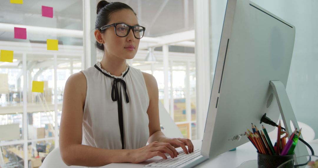Focused Woman Working at Office Computer in Modern Workspace