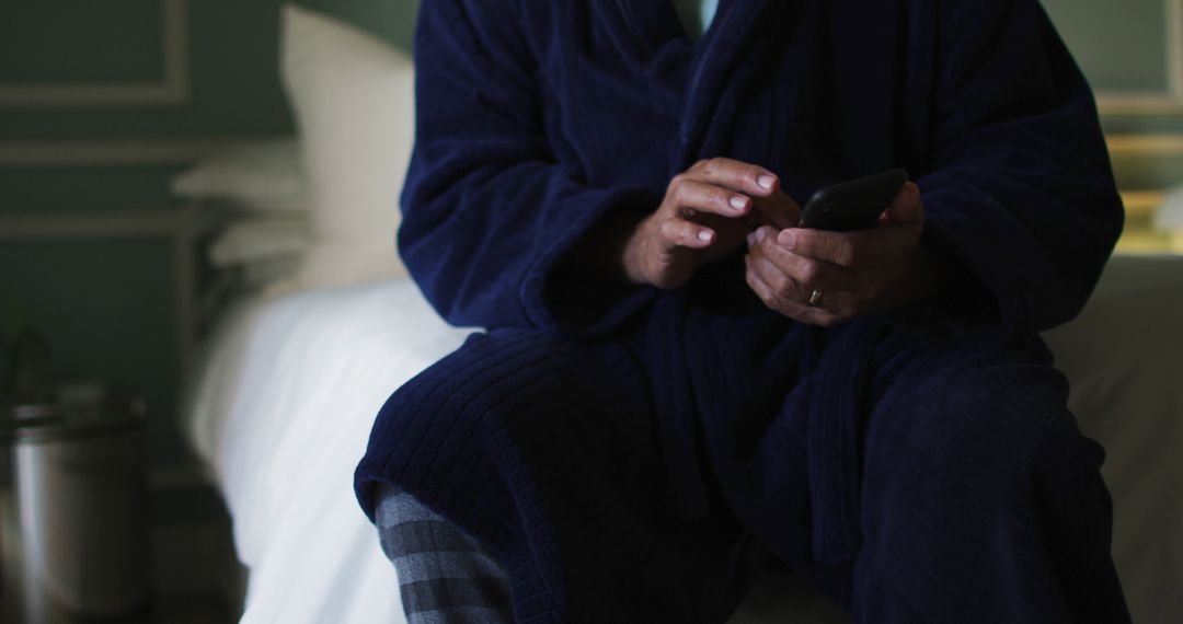 Man in Dark Blue Robe Using Smartphone on Bed - Free Images, Stock Photos and Pictures on Pikwizard.com