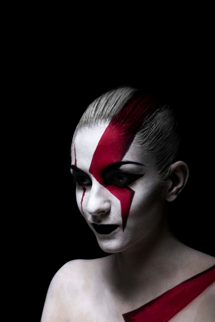 Woman with Artistic Red and White Face Paint on Black Background - Free Images, Stock Photos and Pictures on Pikwizard.com