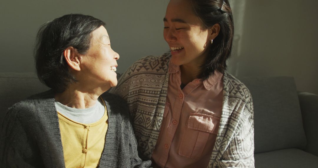 Elderly Woman and Daughter Smiling Together on Sofa - Free Images, Stock Photos and Pictures on Pikwizard.com