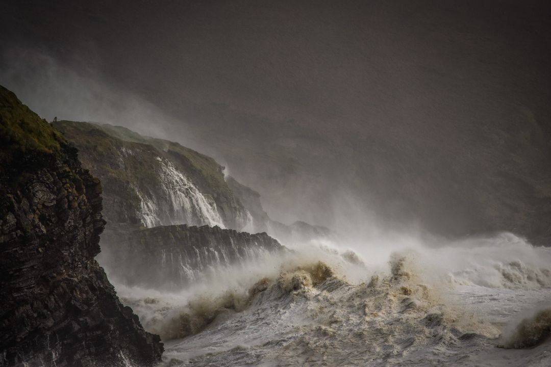 Storm Waves Crashing Against Rugged Coastal Cliffs and Cascading Waterfalls