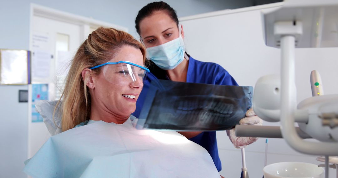 Female Dentist Showing X-ray to Patient in Dental Office - Free Images, Stock Photos and Pictures on Pikwizard.com