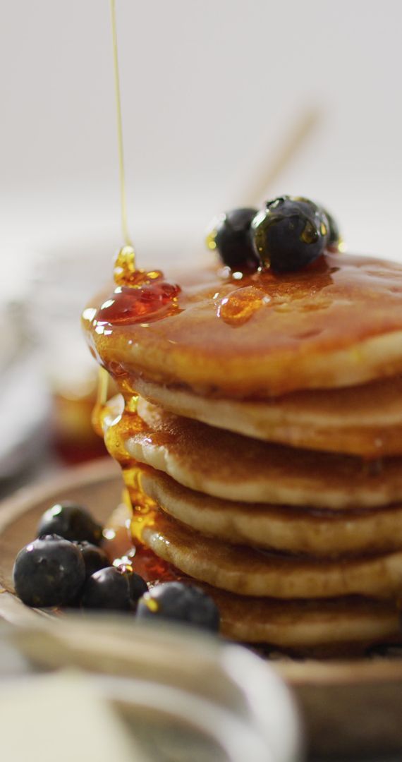 Maple Syrup Drizzling on Pancake Stack with Blueberries