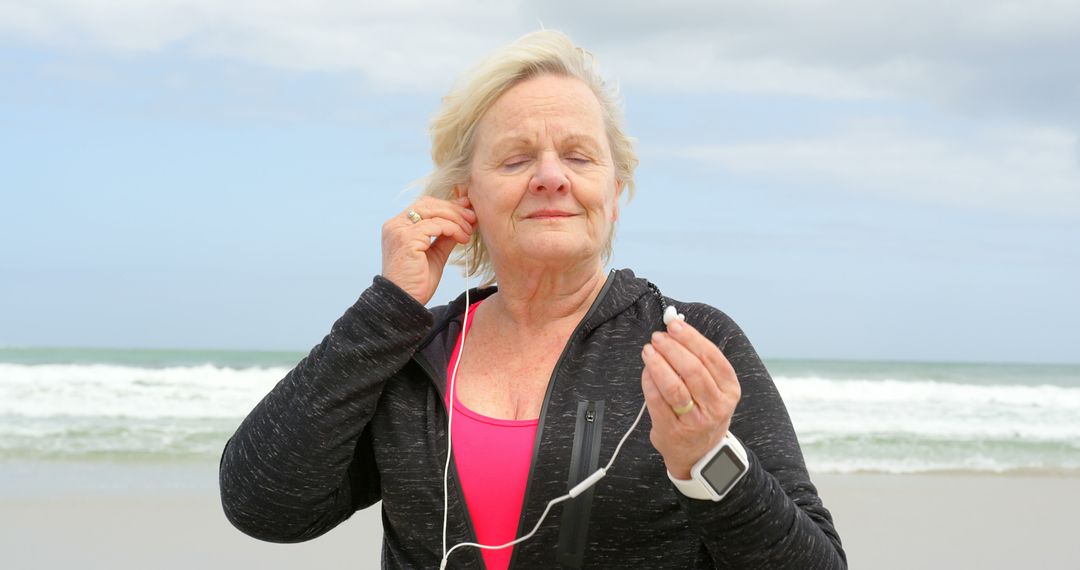 Senior Woman Enjoying Music on Beach in Activewear - Free Images, Stock Photos and Pictures on Pikwizard.com