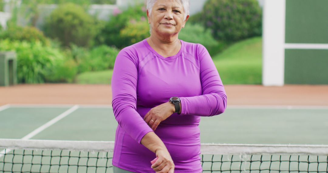 Senior Woman in Purple Sportswear on Tennis Court Relaxing - Free Images, Stock Photos and Pictures on Pikwizard.com