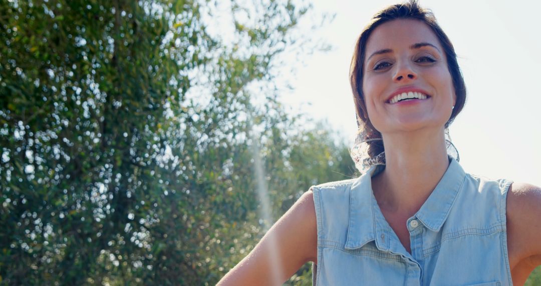 Smiling Woman Outdoors on Sunny Day with Trees in Background - Free Images, Stock Photos and Pictures on Pikwizard.com