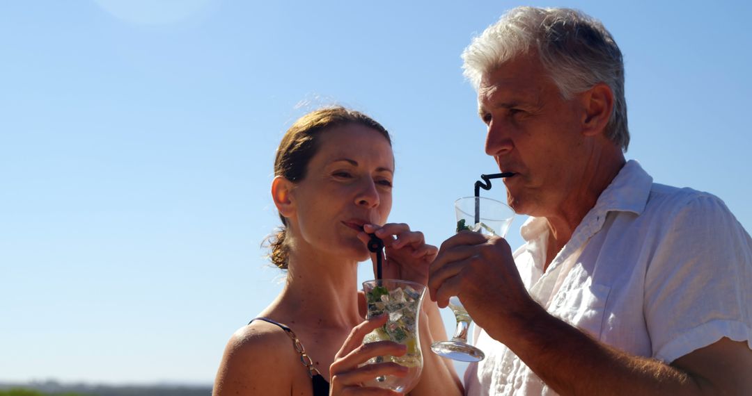 A couple shares a serene moment with drinks under the blue sky, symbolizing intimacy. - Free Images, Stock Photos and Pictures on Pikwizard.com