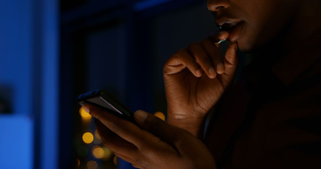 Worried Person Using Smartphone at Night with City Lights in Background - Free Images, Stock Photos and Pictures on Pikwizard.com