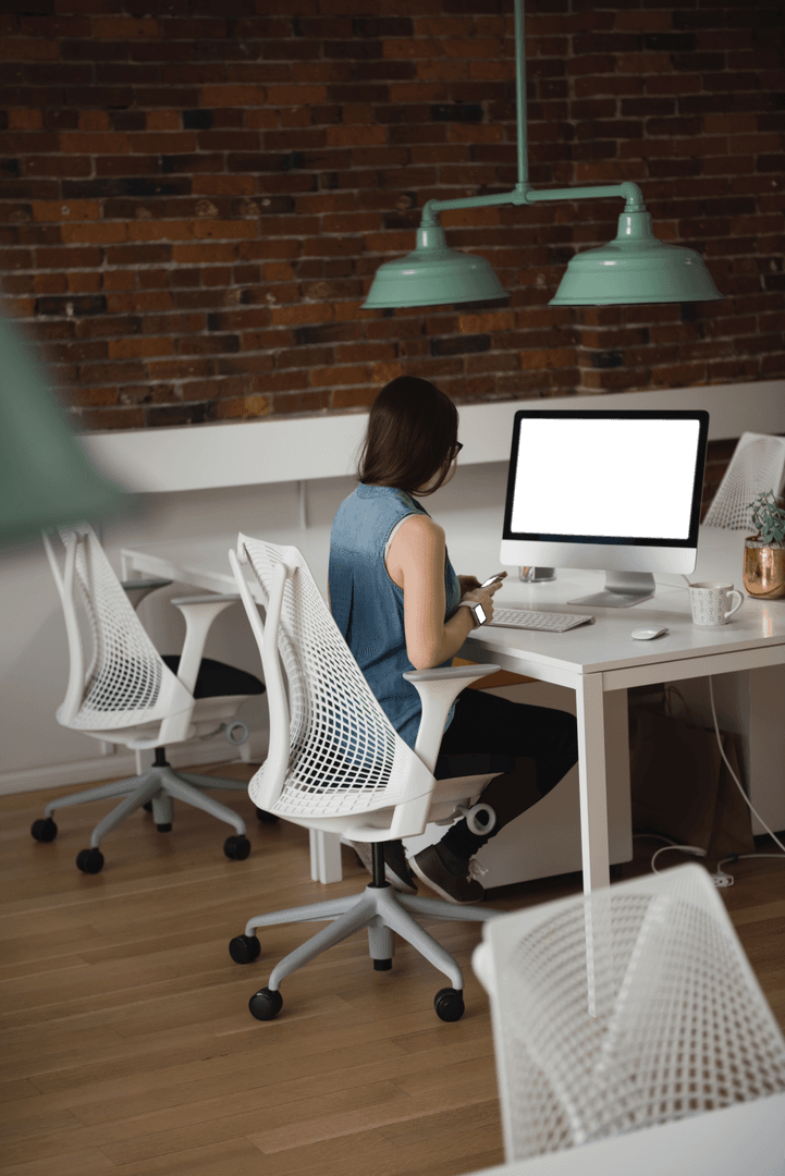 Woman in Transparent Chair Browsing Mobile at Modern Office Desk