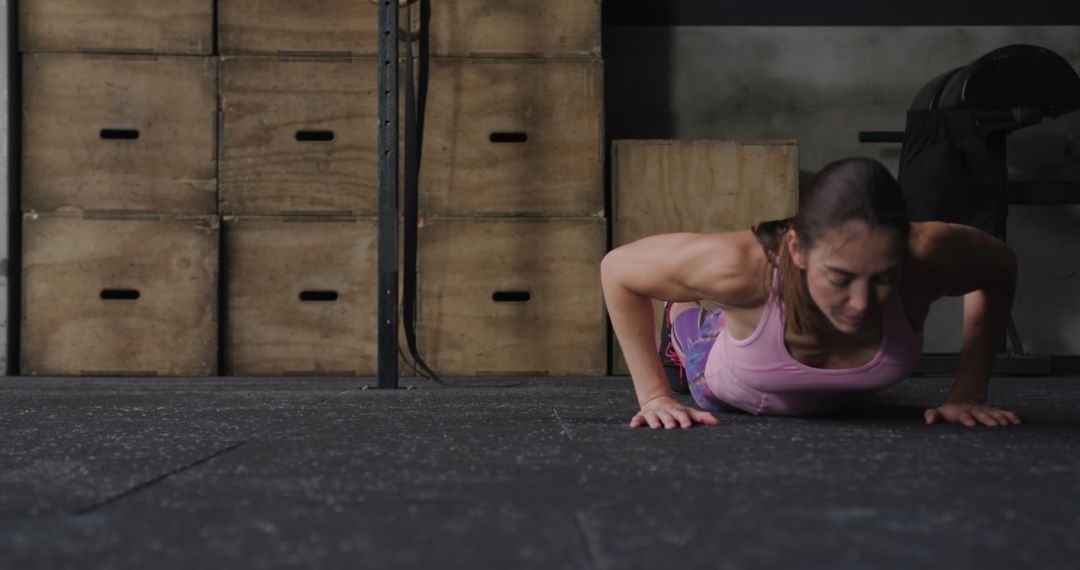 Fit Woman Executing Burpee in Industrial Gym Setting