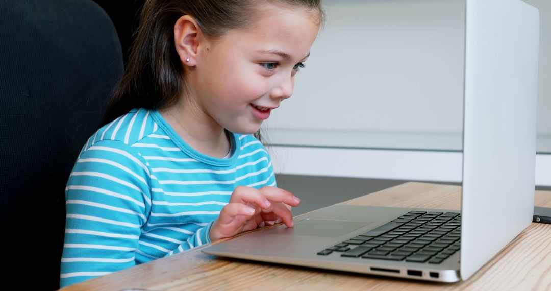 Smiling Girl Engaged with Laptop at Home for Online Learning