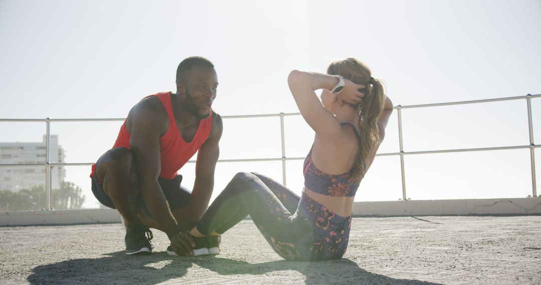 Personal Trainer Helping Woman with Sit-ups on Outdoor Terrace - Free Images, Stock Photos and Pictures on Pikwizard.com