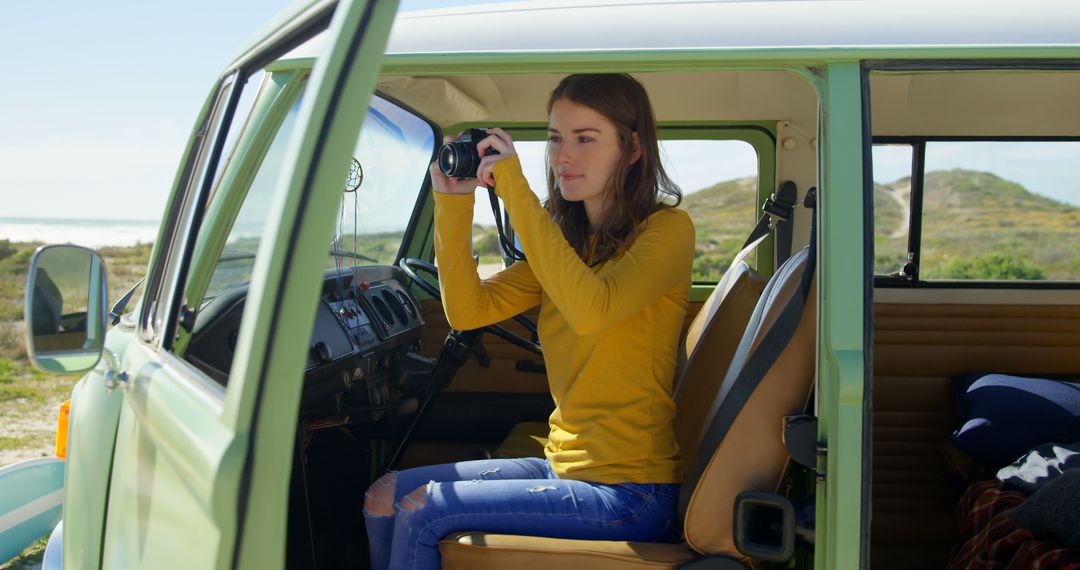 Woman in Yellow Sweater Using Camera Inside Retro Van - Free Images, Stock Photos and Pictures on Pikwizard.com