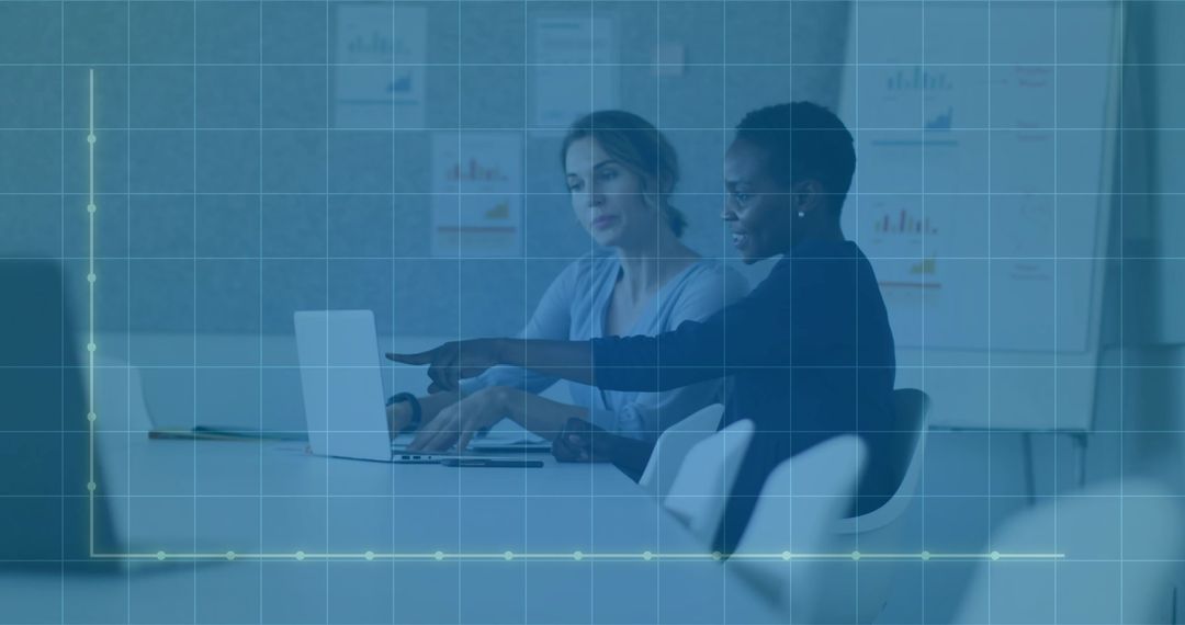 Business Women Collaborating at Laptop Pointing and Typing with Data Overlay