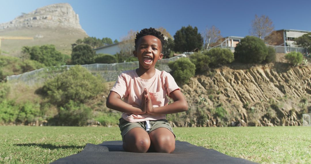 Joyful Boy Practicing Yoga in Nature at Grass Field