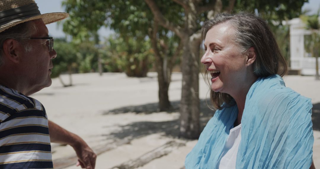 Smiling Senior Couple Chatting on Scenic Beach