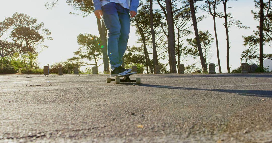 Man skateboarding on serene forest road at sunset - Free Images, Stock Photos and Pictures on Pikwizard.com