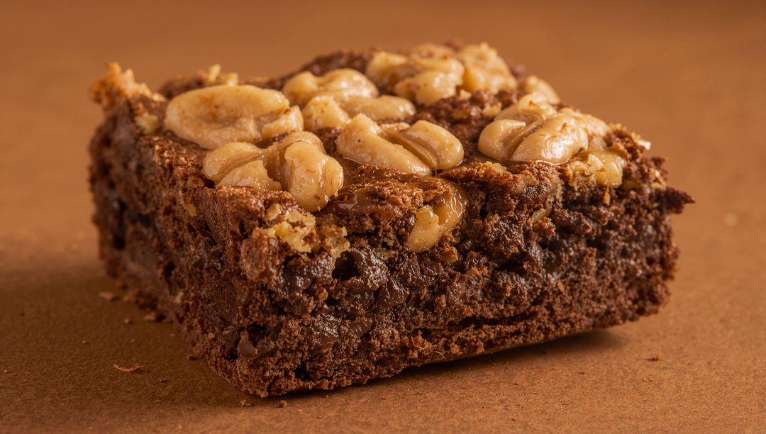 Nut-Topped Chocolate Brownie Square With Glossy Peanut Caramel Topping Close-Up
