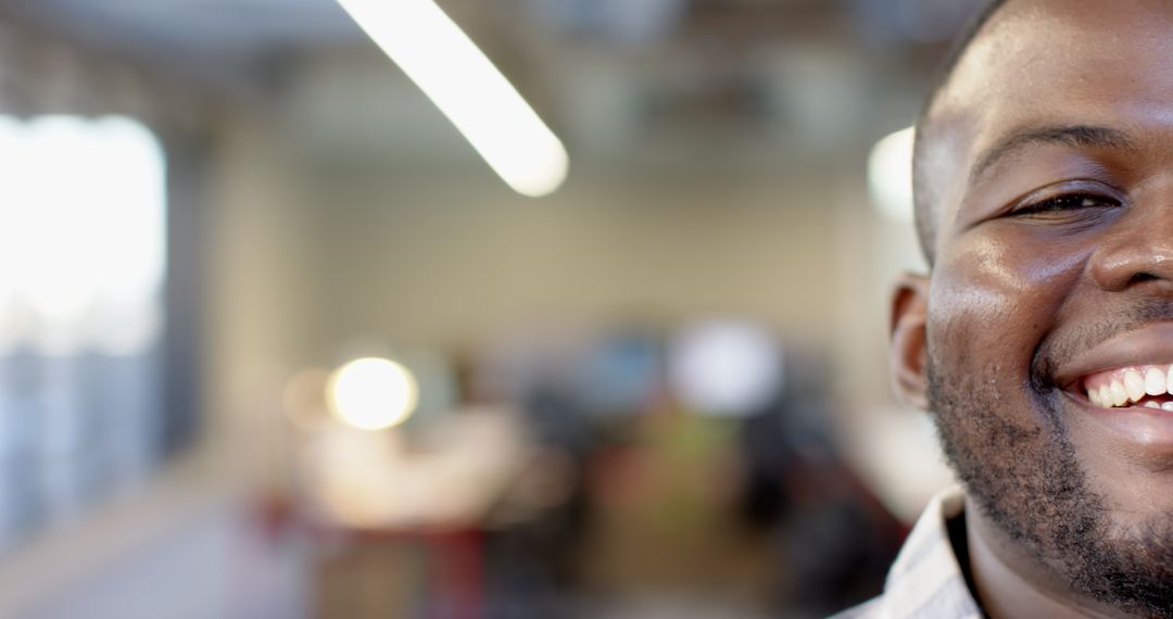 Close-Up of Smiling Young Man in Bright Office Environment
