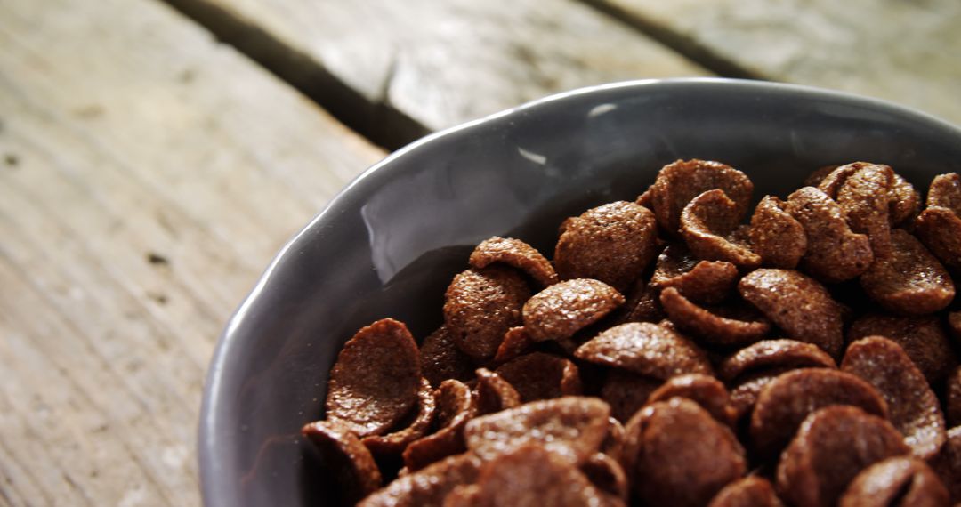 Close-Up of Chocolate Cereal in Gray Bowl on Wooden Table - Free Images, Stock Photos and Pictures on Pikwizard.com