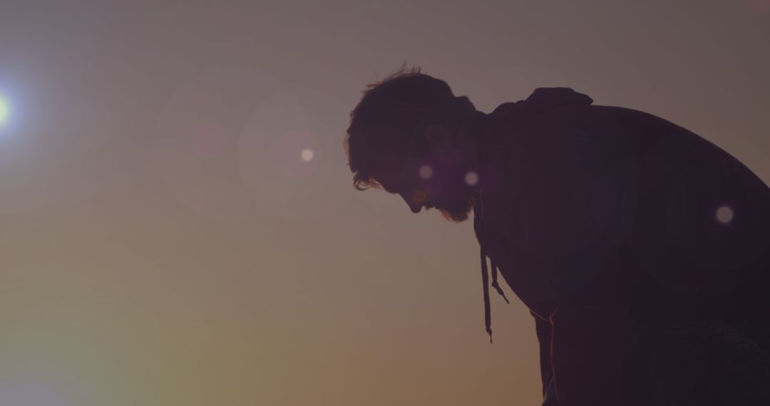 Silhouette of Contemplative Man at Sunset