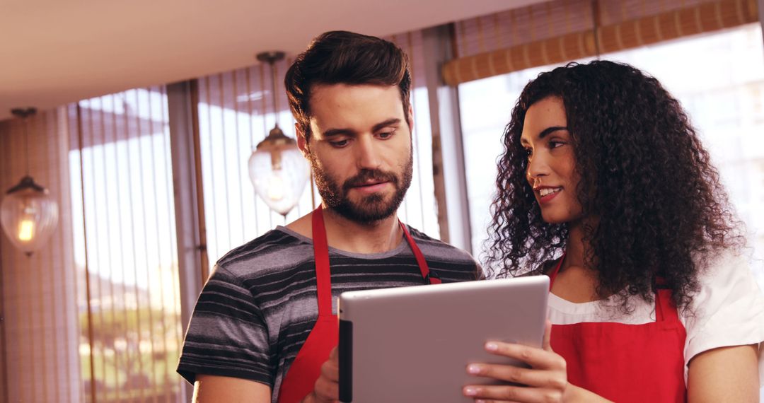 Cafe Staff Collaborating with Digital Tablet behind the Counter