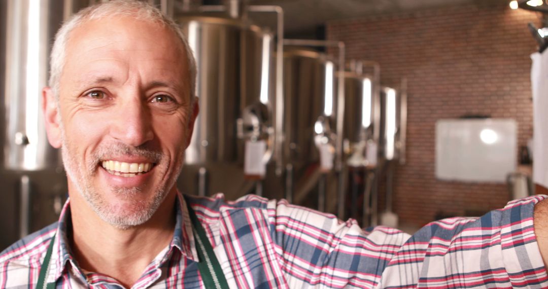 Portrait of Smiling Brewer in Craft Brewery with Fermentation Tanks - Free Images, Stock Photos and Pictures on Pikwizard.com