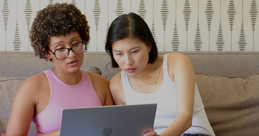 Diverse Friends Using Laptop Together on Couch