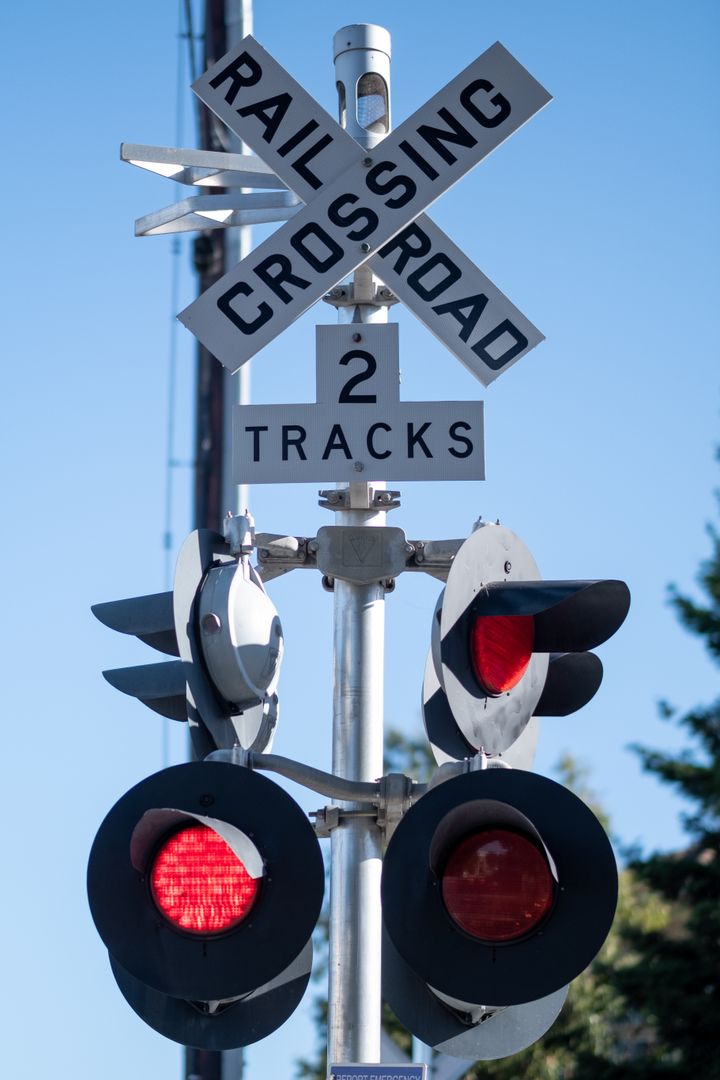 Railroad Crossing with Red Signal Lights on Clear Day