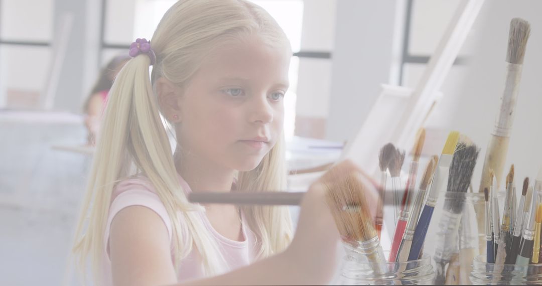 Young Schoolgirl Painting in Art Class with Brushes