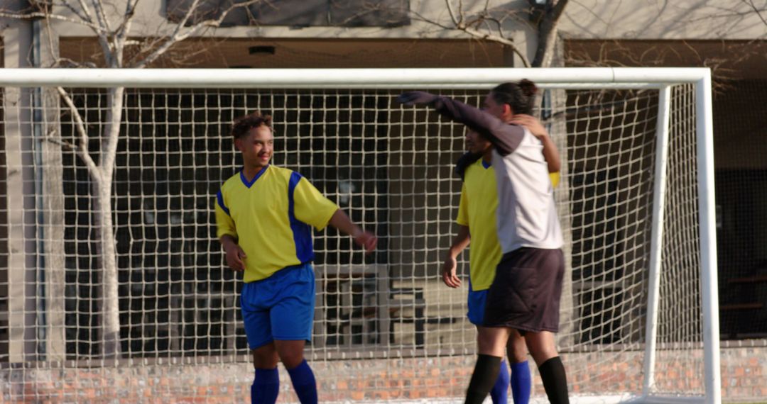 Confident Soccer Players Celebrating in Front of Goalpost