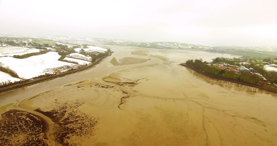 Aerial View of Snow-Covered Riverbank and Mudflats in Winter - Free Images, Stock Photos and Pictures on Pikwizard.com