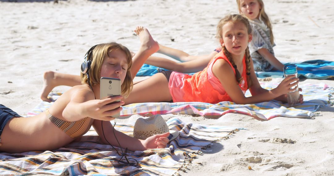 Children Relaxing on Beach Using Smartphone - Free Images, Stock Photos and Pictures on Pikwizard.com