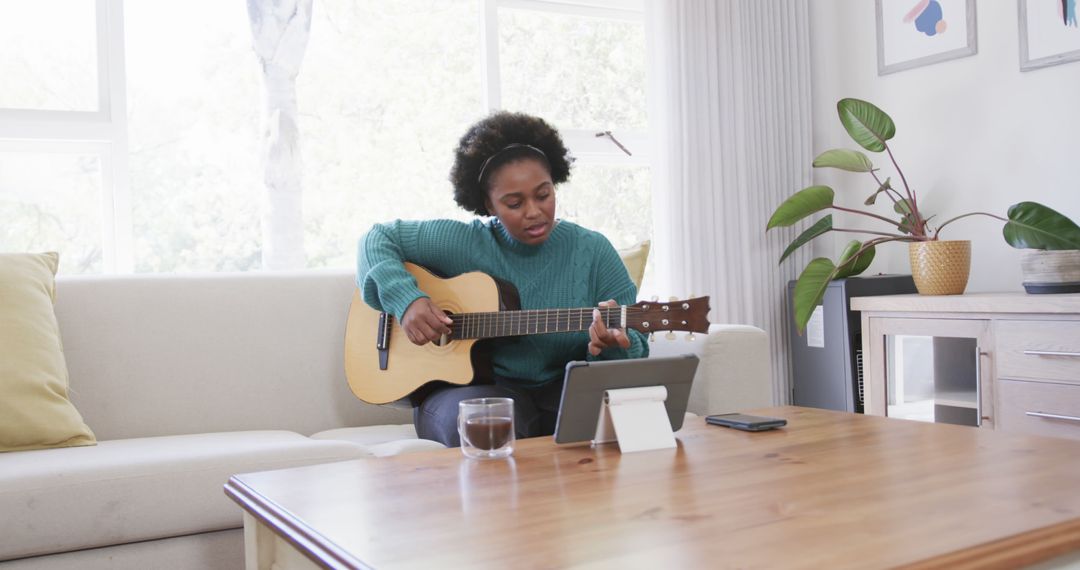 African American Woman Learning Guitar at Home Using Online Tutorial - Free Images, Stock Photos and Pictures on Pikwizard.com