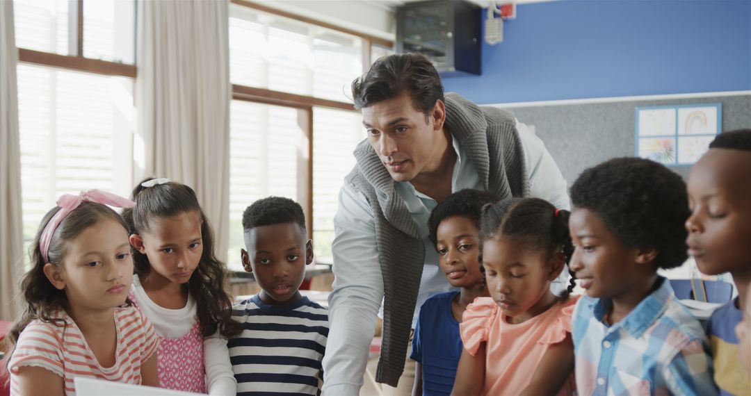 Diverse Teacher Engaging Students with Laptops in Classroom Setting