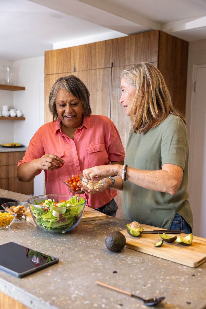 Diverse Friends Bonding While Preparing Healthy Salad in Modern Kitchen