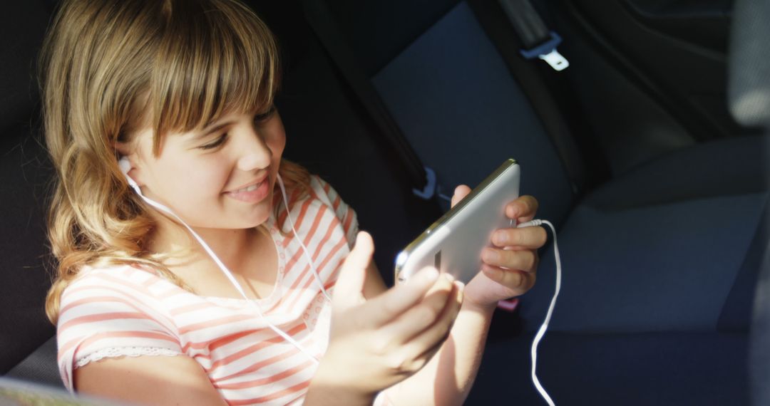 Young Girl Enjoying Video on Smartphone with Earphones - Free Images, Stock Photos and Pictures on Pikwizard.com