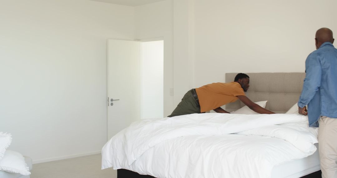 Father and Son Making Bed in Bright Minimalist Bedroom