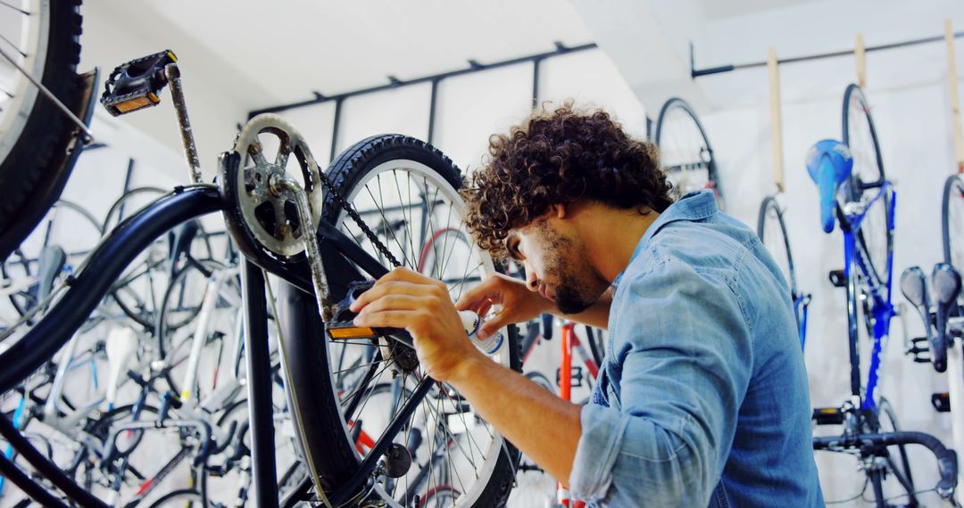 Mechanic Carefully Repairing Bicycle in Busy Workshop